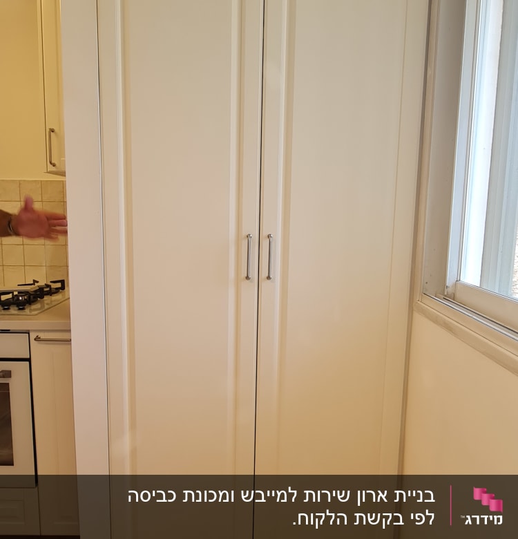 ארון עץ לבן עם ידיות מתכת במטבח